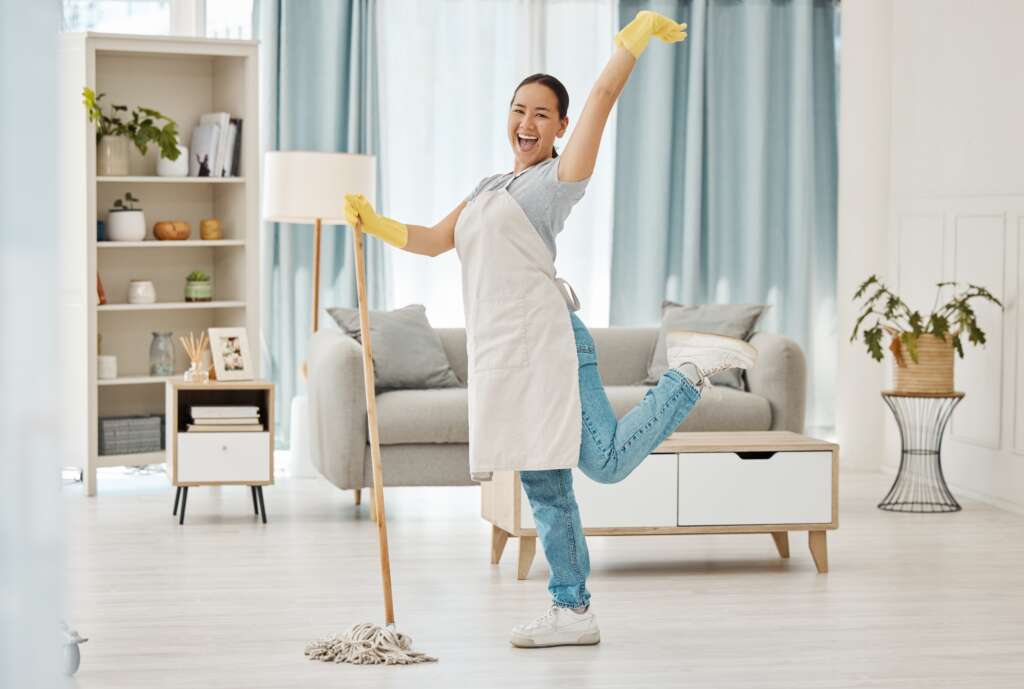 Happy domestic helper mopping the floor, highlighting the benefits of hiring a maid in Singapore.