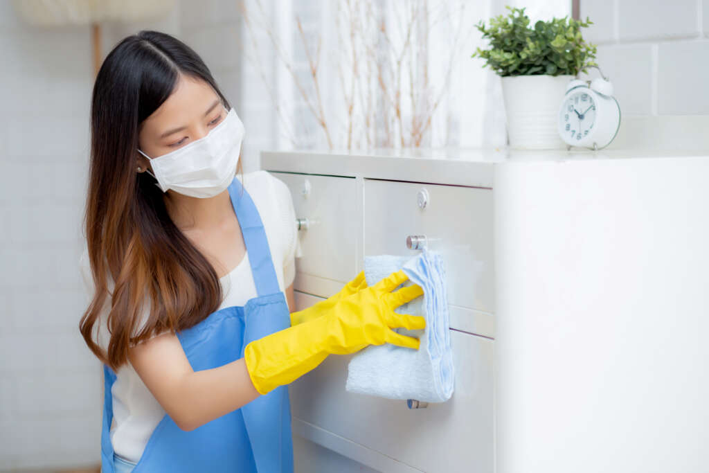 Maid in Singapore cleaning furniture with cloth, supported by a Filipino maid agency Singapore.