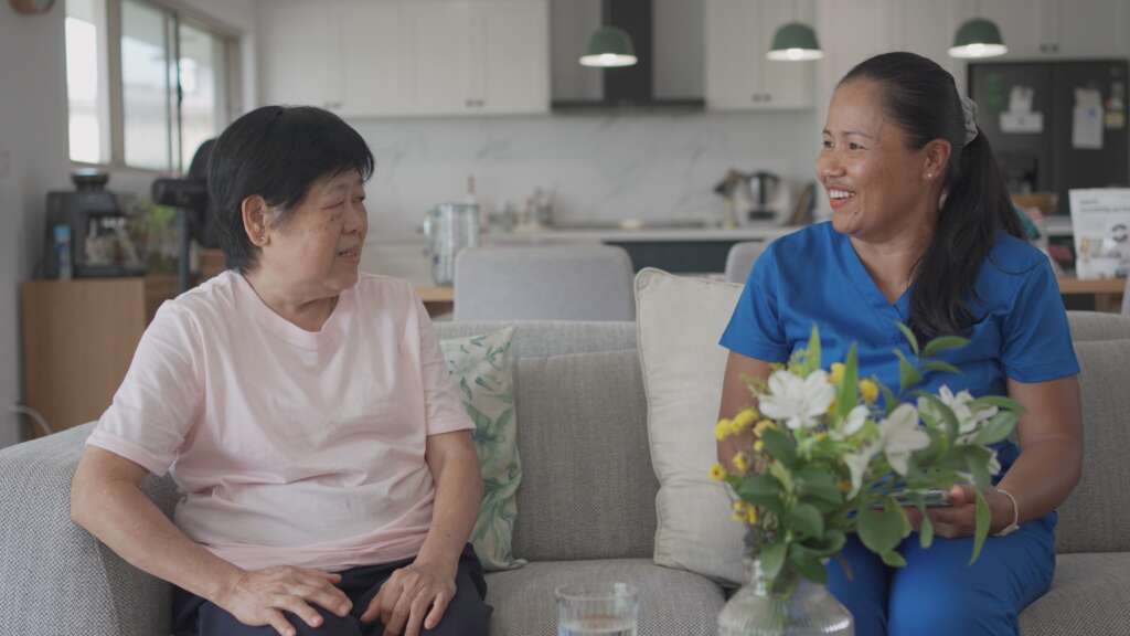 a happy elderly woman with a domestic helper in Singapore