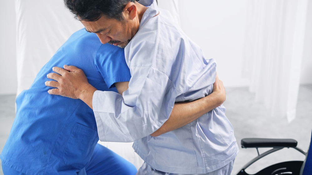 A caregiver assisting a patient to their wheelchair. Elderly and persons with disabilities are indicators of the necesity of hiring a maid in Singapore