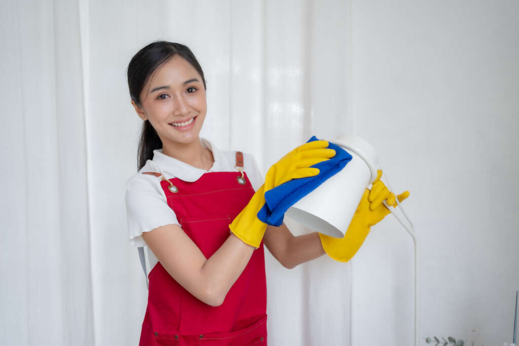 Filipino domestic helper cleaning household items, representing services arranged by a filipino maid agency in Singapore