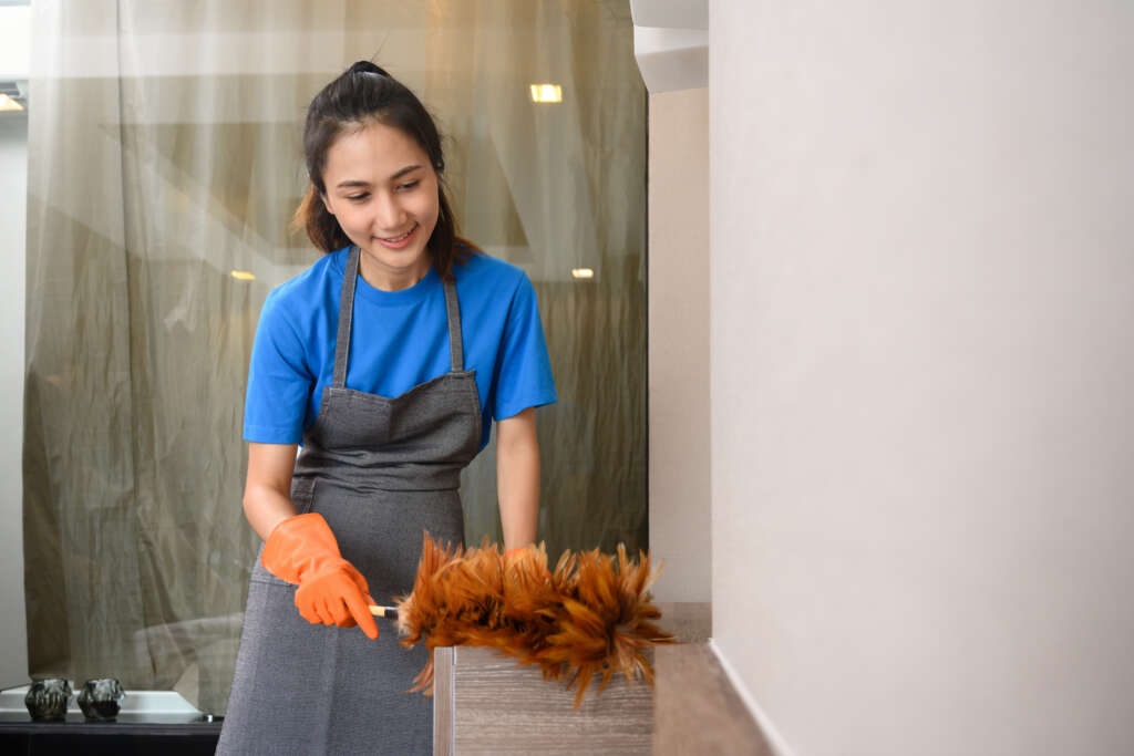Filipino domestic helper performing household cleaning services arranged through a filipino maid agency in Singapore